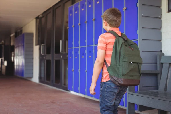 Menino com mochila andando no corredor — Fotografia de Stock