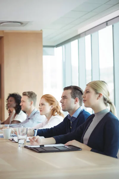 Empresários sentados à mesa de conferências — Fotografia de Stock