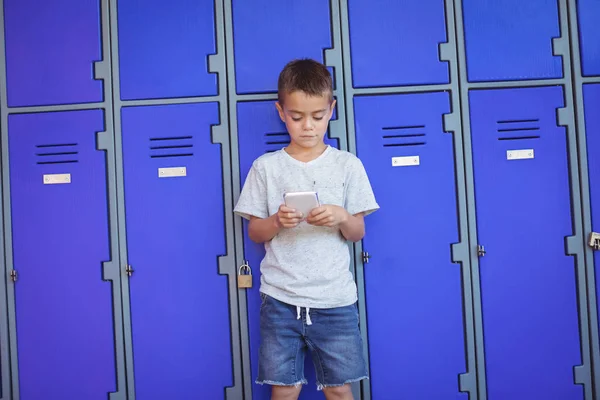 Niño usando el teléfono móvil contra taquillas —  Fotos de Stock