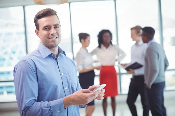 Hombre de negocios usando el teléfono con colegas discutiendo —  Fotos de Stock