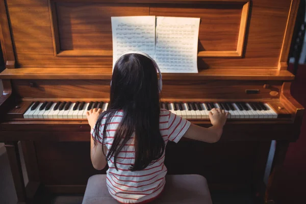 Flicka öva piano i klassrummet — Stockfoto