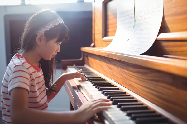 Девушка практикует фортепиано в классе — стоковое фото
