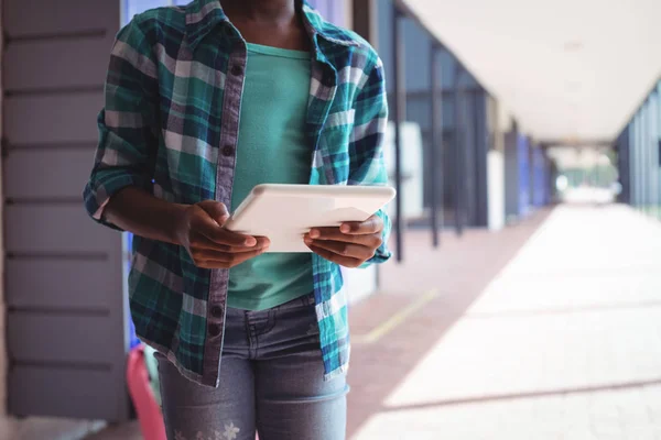 Estudante usando tablet digital no corredor — Fotografia de Stock