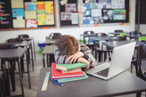Trött skolpojke sover på stacken bok — Stockfoto