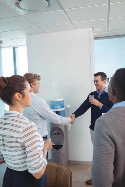 Colegas de negocios felices estrechando las manos en la oficina — Foto de Stock