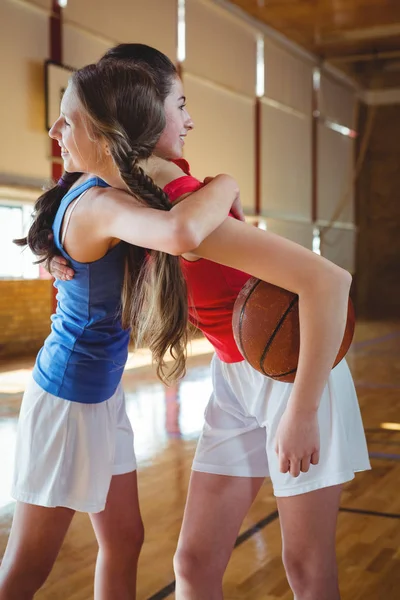Kvinnliga spelare omfamnar i basketplan — Stockfoto