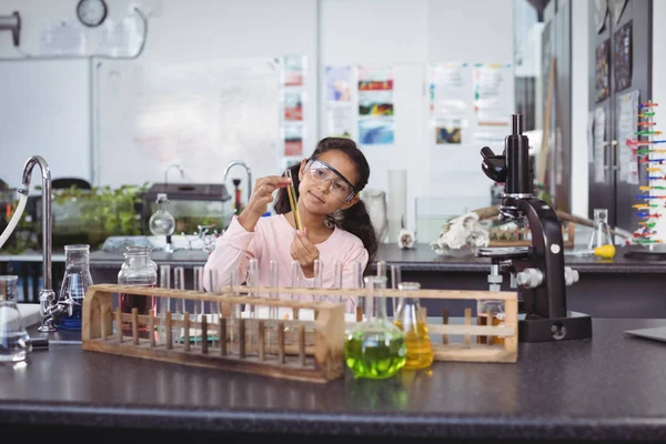 Studentessa elementare che tiene la provetta in laboratorio — Foto Stock