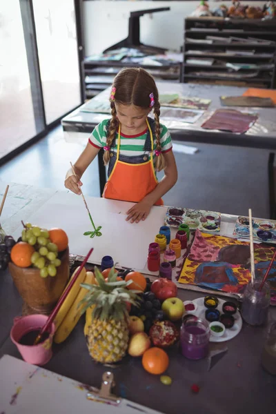 Meisje schilderij op papier aan balie — Stockfoto