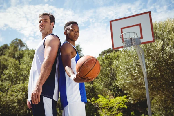 Jugadores de baloncesto de pie espalda con espalda — Foto de Stock