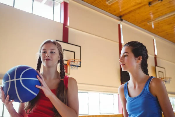 Mulher olhando amigo segurando basquete — Fotografia de Stock