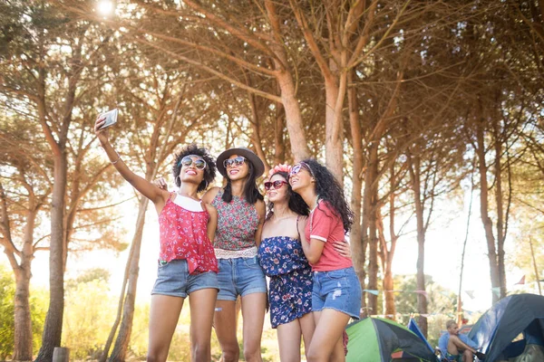 Kvinnliga vänner tar selfie på campingplats — Stockfoto