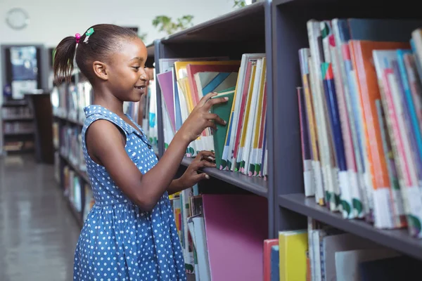 Menina escolhendo Livro na Biblioteca — Fotografia de Stock