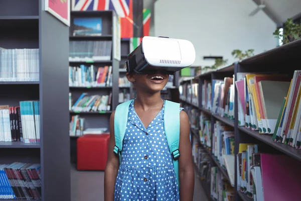 Menina vestindo simulador de realidade virtual na biblioteca — Fotografia de Stock