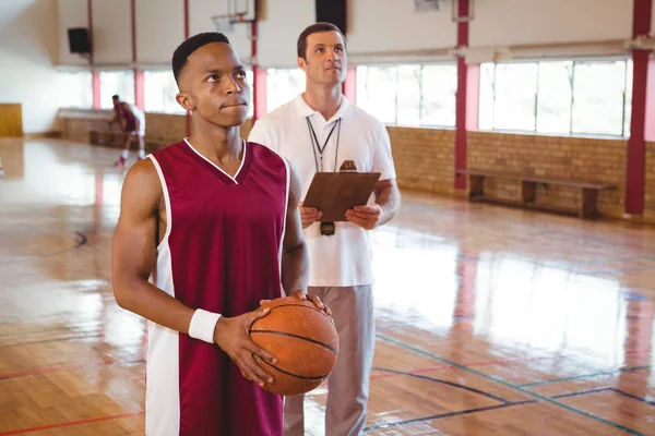 Nachdenklicher Basketballer mit Trainer — Stockfoto
