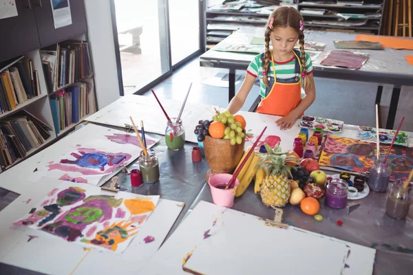 Koncentrerad flicka målning på skrivbord — Stockfoto