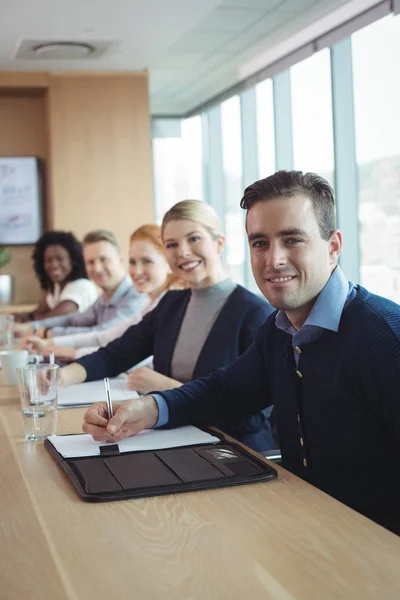 Affärsman med kollegor som sitter på kontor — Stockfoto