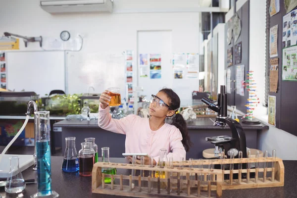 Elementära student att undersöka vätskan i bägare — Stockfoto