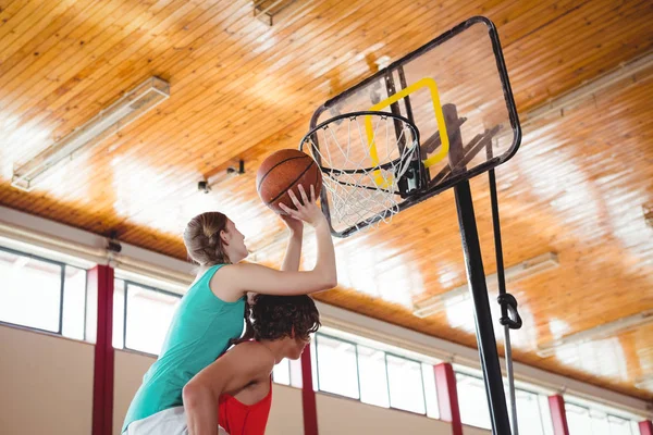 Человек помогает другу во время игры в баскетбол — стоковое фото