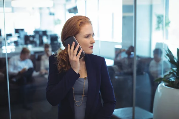 Geschäftsfrau greift zum Telefon — Stockfoto