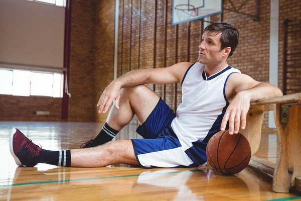 Giocatore di basket premuroso seduto sul pavimento — Foto Stock