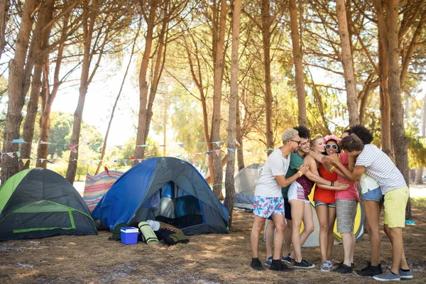 Freunde umarmen sich im Stehen auf dem Feld — Stockfoto