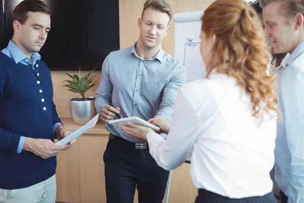 Affärsman som diskuterar över tablett med kolleger — Stockfoto