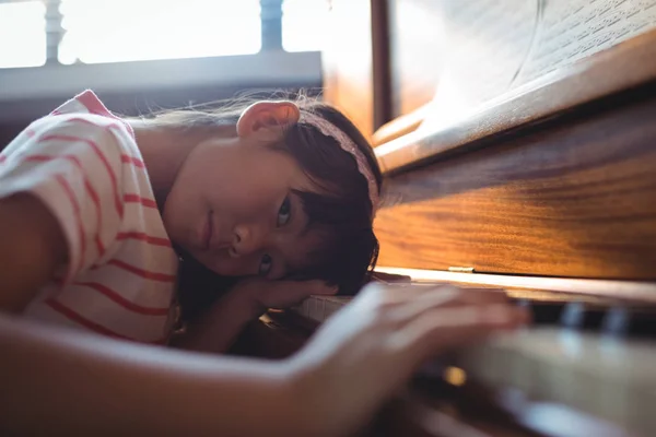 Flicka som lutar på piano i klassrummet — Stockfoto