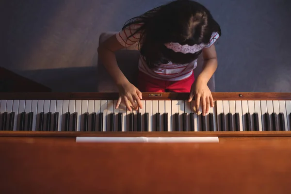 Elementära flicka spela piano i klassrummet — Stockfoto