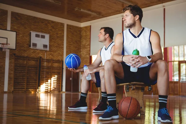 Przemyślane koszykarzy, siedząc na ławce — Zdjęcie stockowe