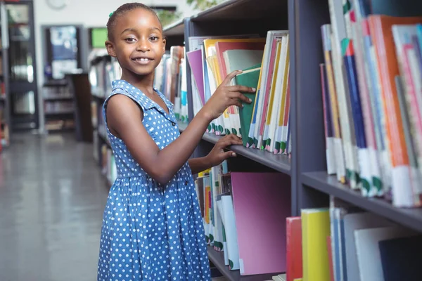 Κορίτσι επιλογή βιβλίο στη βιβλιοθήκη — Φωτογραφία Αρχείου