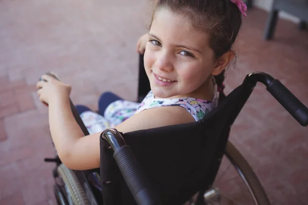 Школьница, сидящая на инвалидной коляске — стоковое фото
