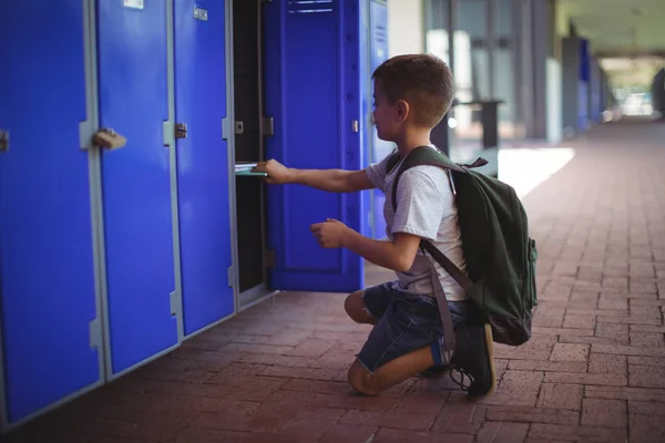 Jongen houden boeken in locker — Stockfoto