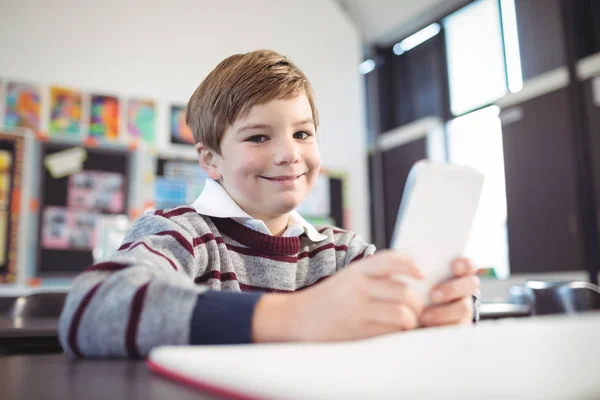 Pojke med hjälp av mobiltelefon vid skrivbord — Stockfoto