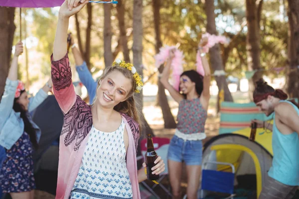 Mujer levantando la mano con amigos en segundo plano — Foto de Stock