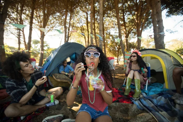 Frau pustet Blasenzauber auf Campingplatz — Stockfoto