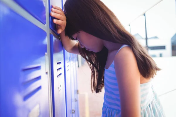 Chica triste apoyándose en casilleros — Foto de Stock
