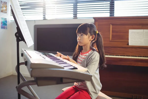 Концентрированная девушка, практикующая фортепиано — стоковое фото