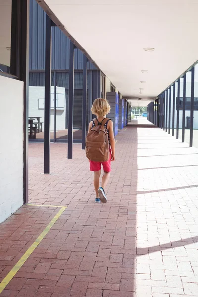 Scholier met rugzak wandelen in gang — Stockfoto