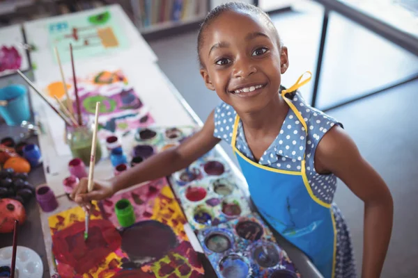 Elementar menina pintura na mesa — Fotografia de Stock