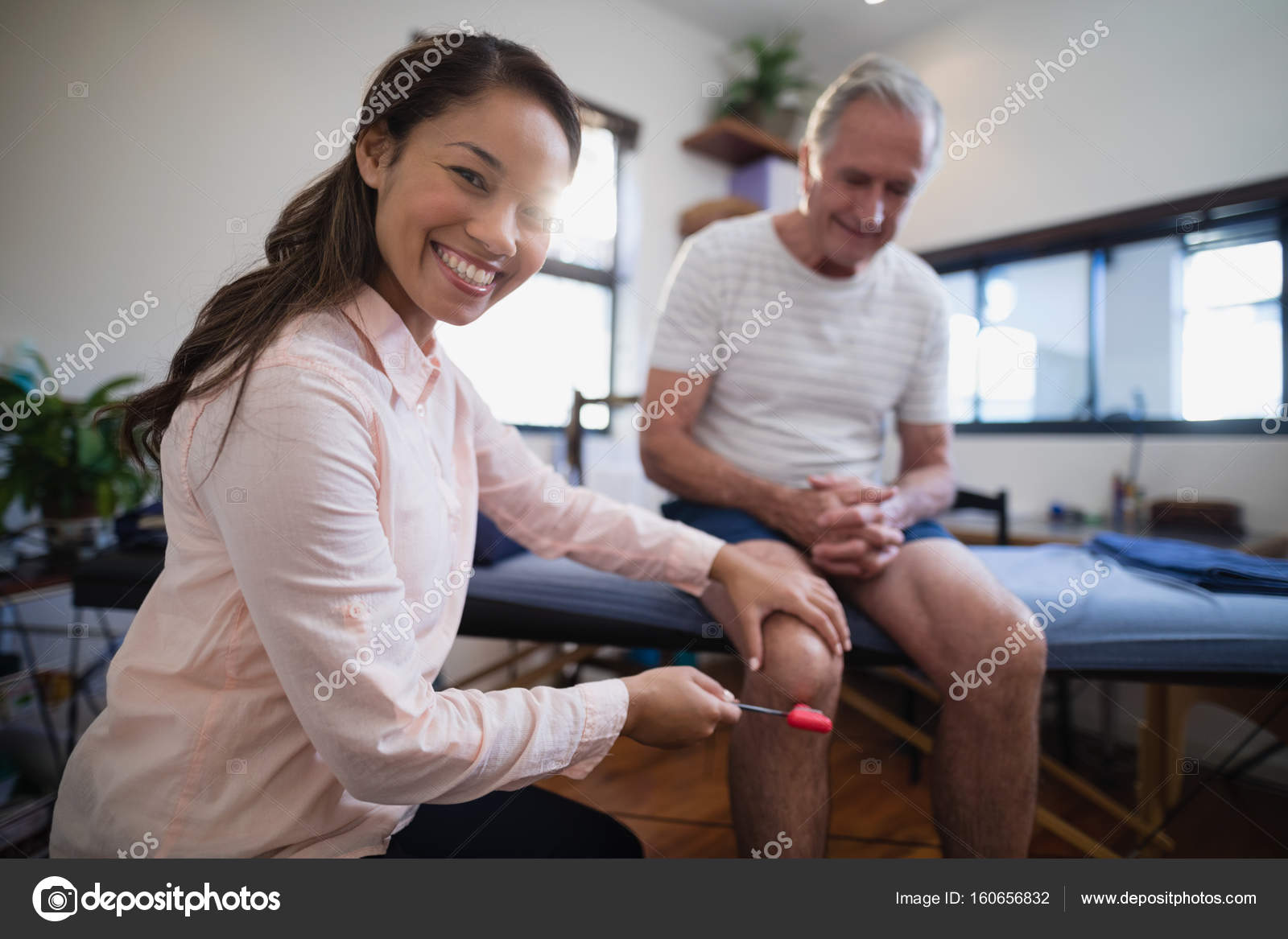 Therapist examining knee of patient with reflex hammer — Stock Photo