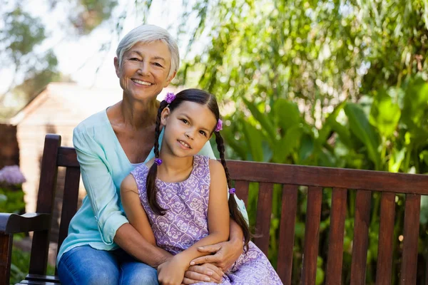 Woman sitting with arm around girl — Stock Photo, Image