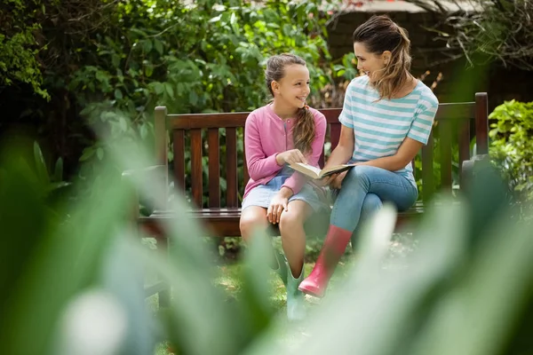 Mor och dotter tittar på var och en på bänk — Stockfoto