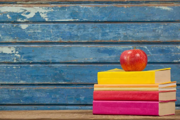 Libros apilados y manzana —  Fotos de Stock