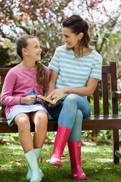 Mother and daughter reading novel — Stock Photo, Image