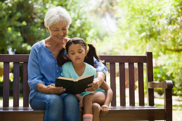 Grand-mère lecture roman à petite-fille — Photo