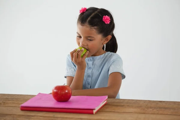 Schoolgirl eating apple — Stock Photo, Image