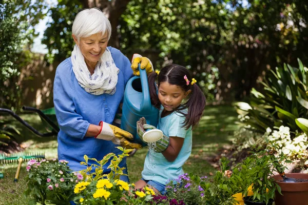 Grandmother and granddaughter watering plants — Stock Photo, Image