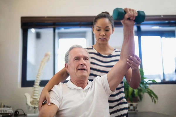 Doktor hasta kaldırma dumbbell arıyorsunuz — Stok fotoğraf