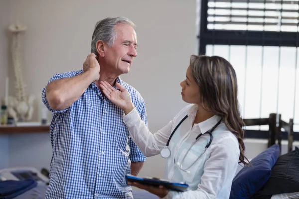 Thérapeute examinant le cou du patient — Photo