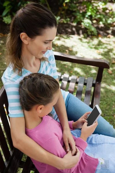 Dochter met behulp van mobiele telefoon — Stockfoto